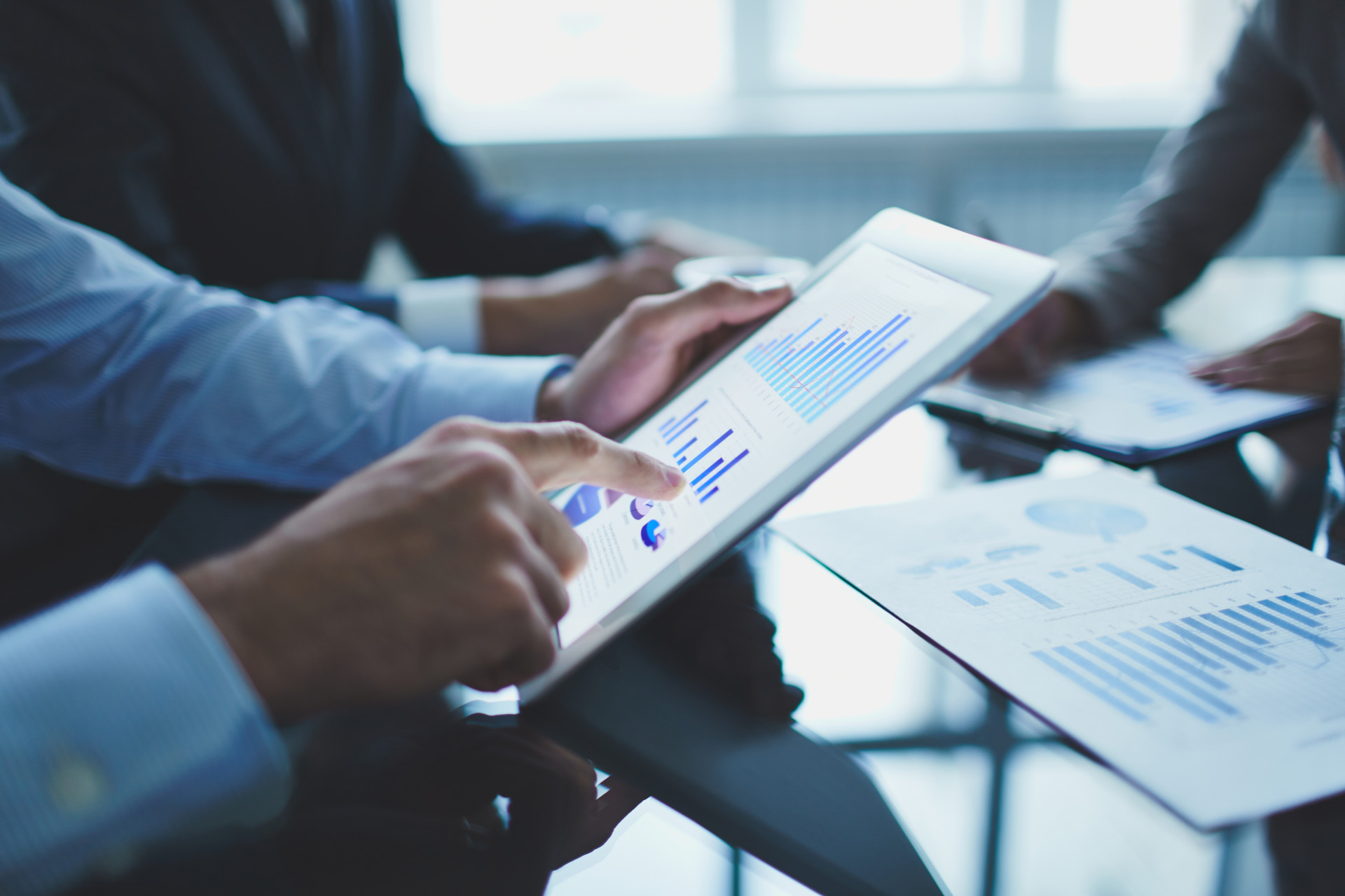 Manos sobre una tableta con gráficos de negocios