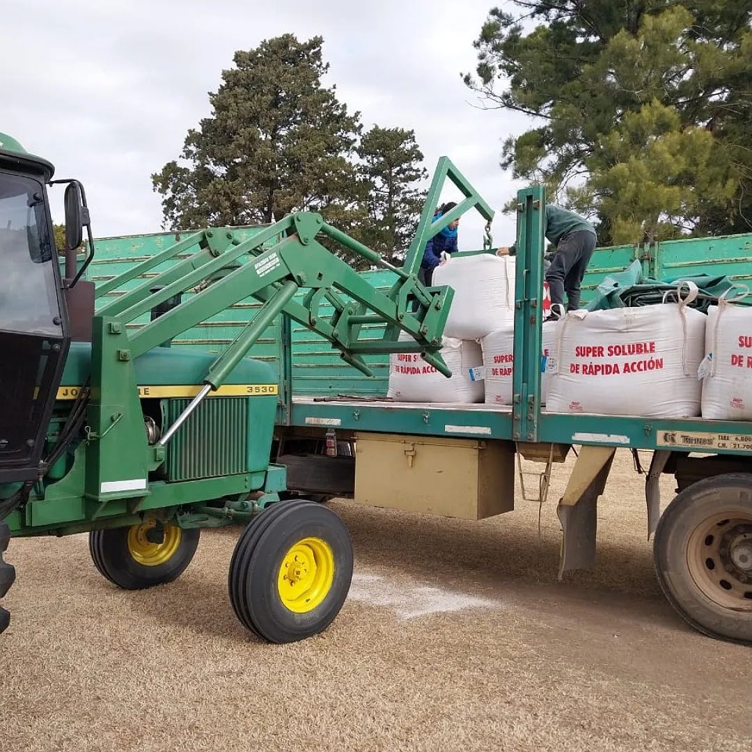 Tractor cargando bolsas de fertilizante en un camión